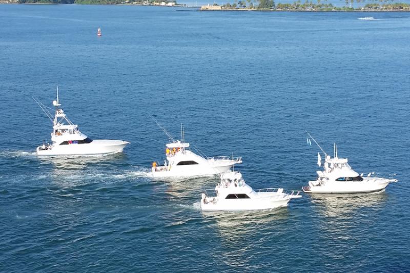 Group of four recreational fishing boats in close proximity moving in the same direction
