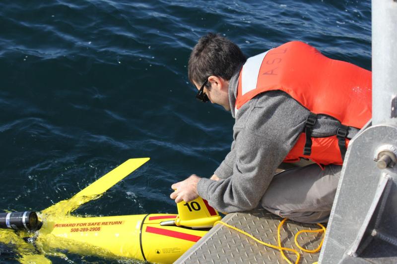 Yellow winged glider being deployed from side of boat. 