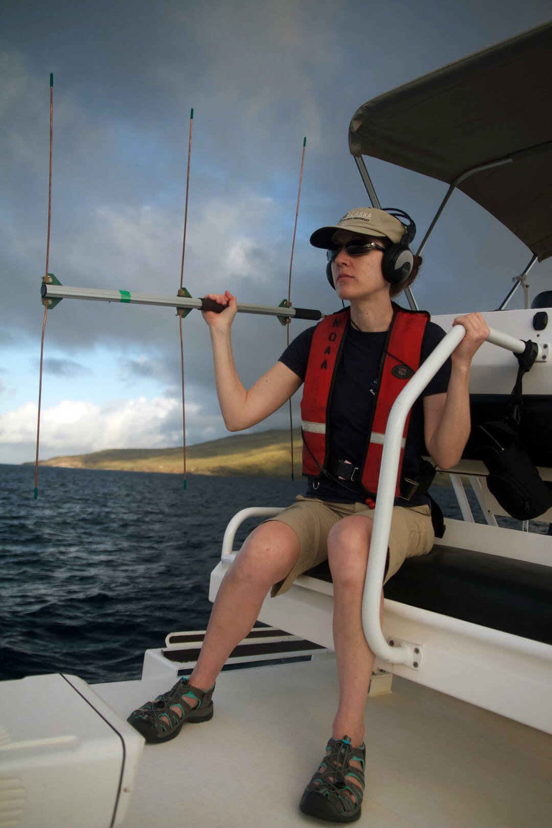 Rachel Finn aboard a vessel holding a large antenna