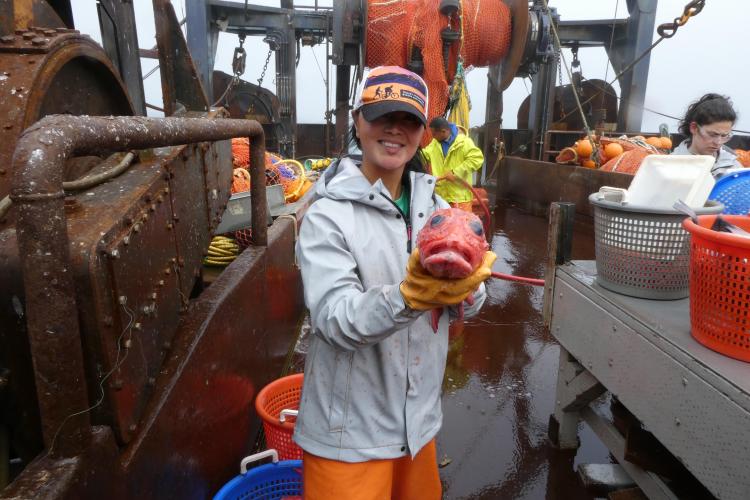 Alaska Native woman researcher holding a rockfish