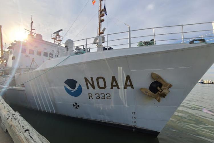 A large white NOAA ship docked in the water