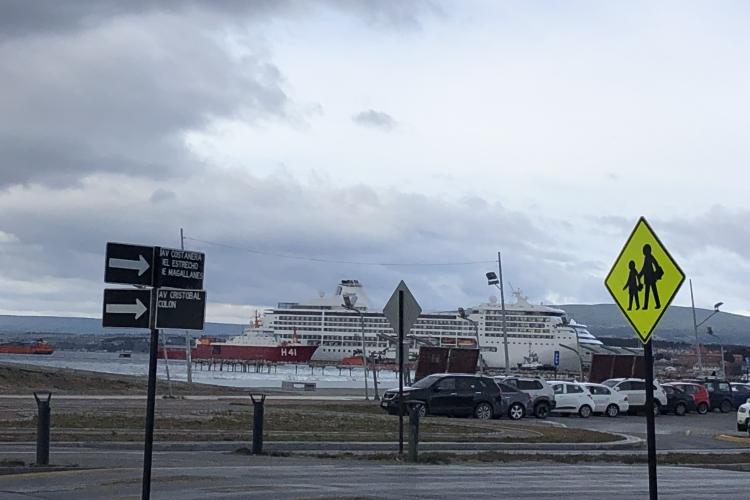 large cruise ship off in distance. Parking lot in fore front.