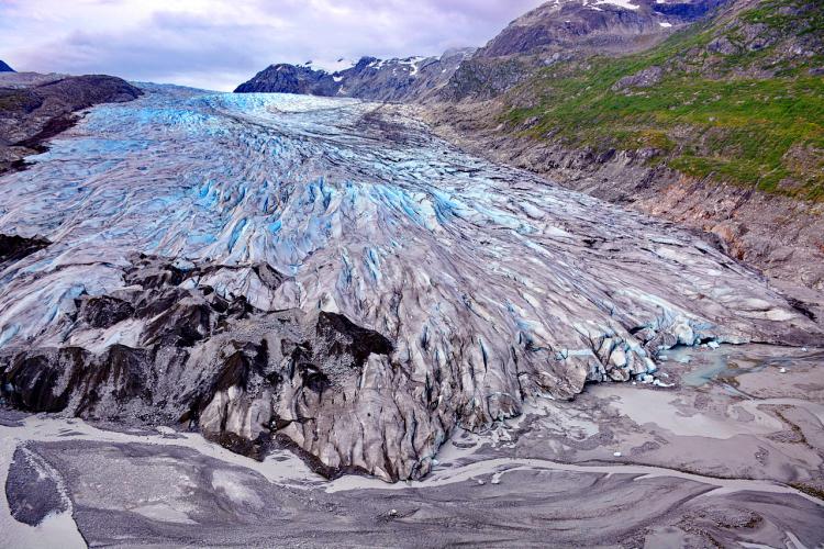 Glacier with green hills and mountains in background 