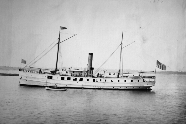 Steamer sailor anchored, American flag flying from stern.