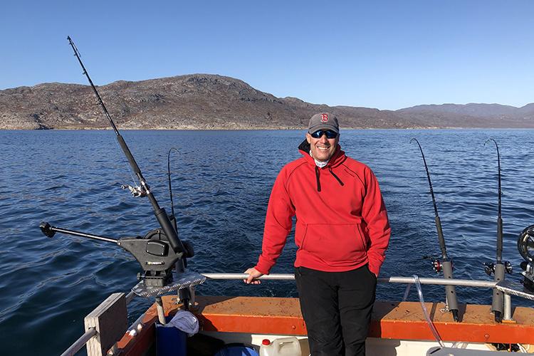 Tim Sheehan at stern of boat, fishing gear set up for trawling in the waters off Greenland.
