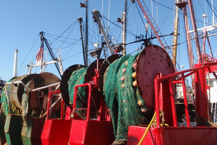 Stern view of  fishing vessells with their trawl nets. 