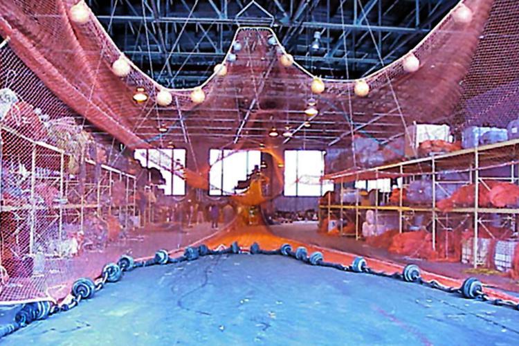 Large red trawl net stretched out in a warehouse