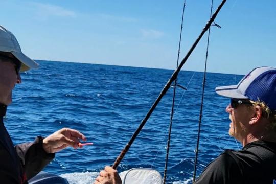 Anglers with recovered spaghetti fish tag.