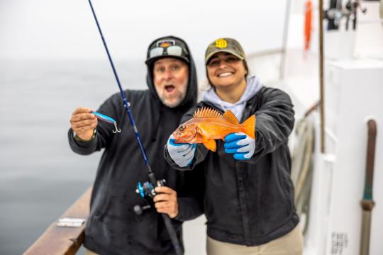 Anglers hold a vermillion rockfish. 