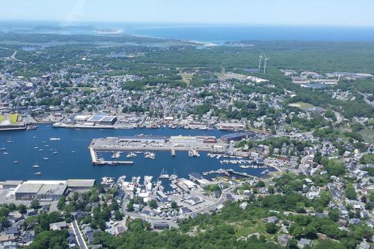 Gloucester, Massachusetts as seen from the air. Harbor is center wind turbines to the right.