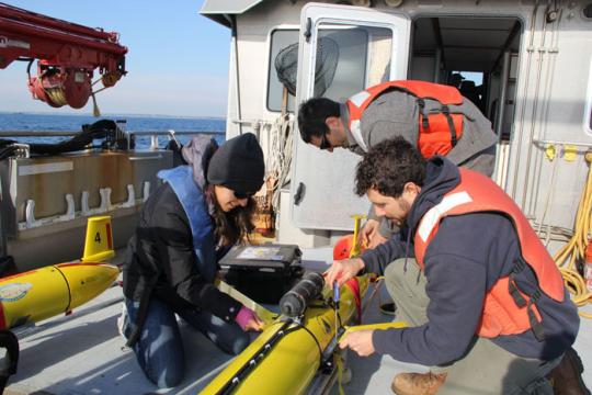 Crew setting up acoustic robots on deck.