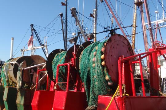 Stern view of  fishing vessells with their trawl nets. 