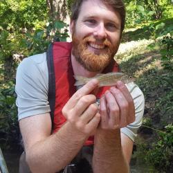 Picture of Jonathan Watson holding a small fish.