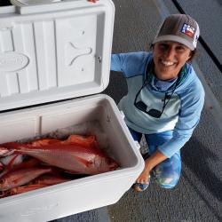 Photo of Erin Reed next to an open cooler of bottomfish.