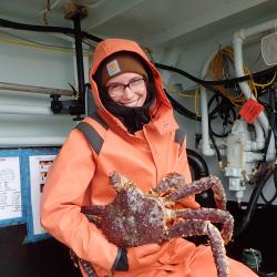 Photo of Allie Conrad holding a large crab.