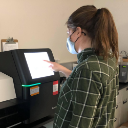 Genetics researcher using a genome sequencing machine.