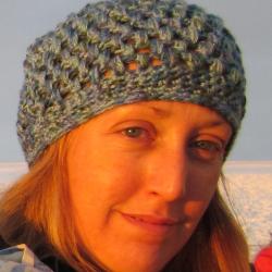 Jen wearing a knit cap with snow in the background