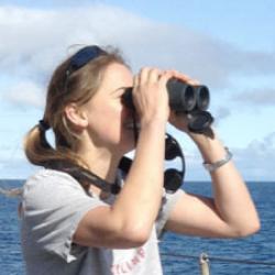 Laura Lilly looking through binoculars.