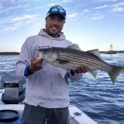 Man on boast holding fish.