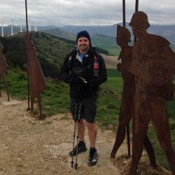 Picture of Doug Christel standing on Mountain with windmills in background