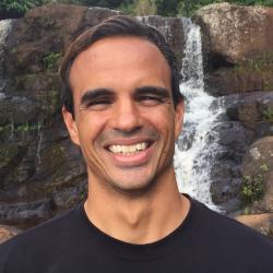 Felipe Carvalho standing in front of a waterfall