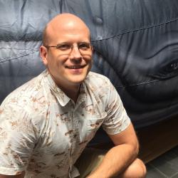 Photo of John Syslo in front of an inflatable model of a whale