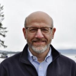 Jon Kurland smiling in front of seashore