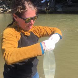 Meredith Pochardt sampling water for eDNA in Alaska