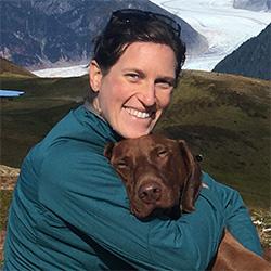 Woman smiling with brown dog 