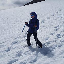 Woman walking down snowy mountain