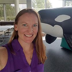 Woman smiling with Orca in background 