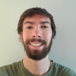 Smiling man with beard wearing a green t-shirt.