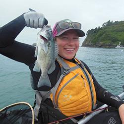 Woman smiling holding up a fish