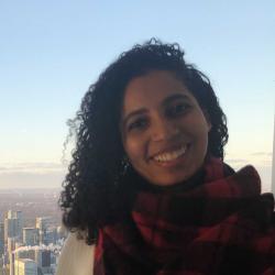 Gabi McMurty in red plaid scarf with the city in the background.