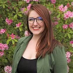 Portrait of woman with glasses, flowers and leaves in background. 