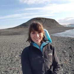 Female NOAA Fisheries employee with brown hair in front of glacial lagoon.