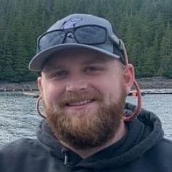 Portrait of scientist wearing a hat with water and trees in background