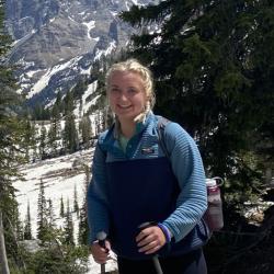 Haley Synan wearing blue shirt and ski pants on mountain.
