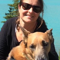 Anne Marie Eich with her dog with water and forest in the background
