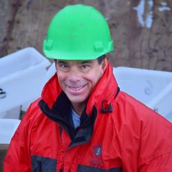 Man with green helmet and orange coat 