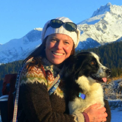 Julie Scheurer with her dog and mountains in the background