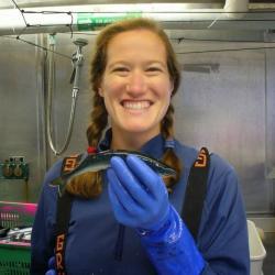 Molly Zaleski wearing rubber gloves and holding a fish