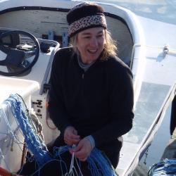 Beth Josephson holding net while sitting in gunwale. 