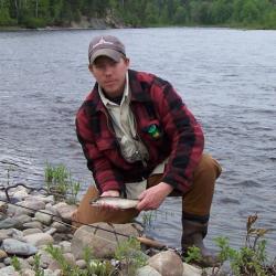 Doug Sigourney with catch by waters edge.