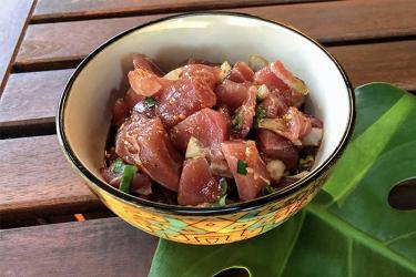 Cut ahi (tuna) into cubes in a bowl.
