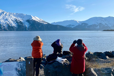 Members of the Alaska Beluga Monitoring Program use binoculars to look for beluga whales in Alaska's Cook Inlet. Credit: NOAA Fisheries