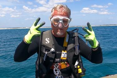 Jeff Gearhart wearing dive gear and ready to dive on a trawl to test a new turtle excluder device.