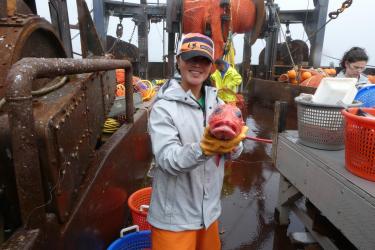 Alaska Native woman researcher holding a rockfish