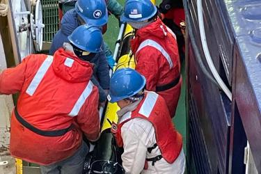 team of scientists on side of boat holding onto recovered glider.