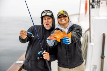 Anglers hold a vermillion rockfish. 